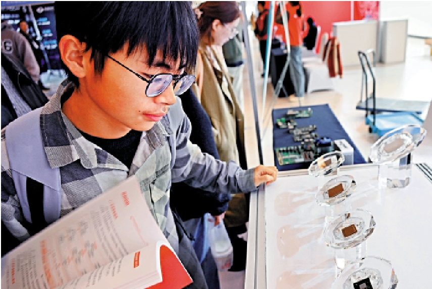 圖:去年11月2日,一名觀眾在山東省青島市一場展覽上觀看國產芯片。\新華社