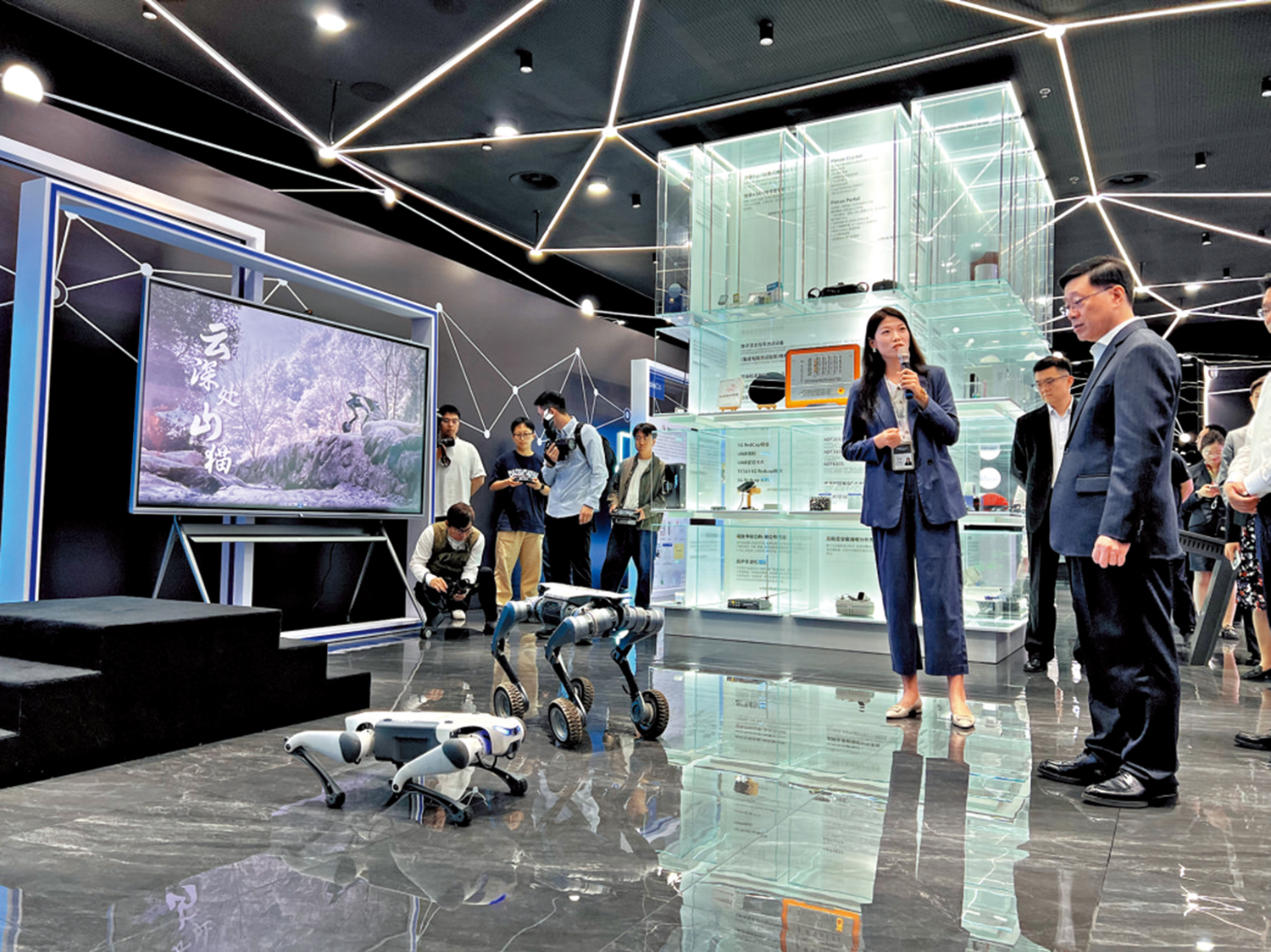 圖:李家超在杭州未來科技城展館觀看機器貓表演。\大公報記者俞晝攝