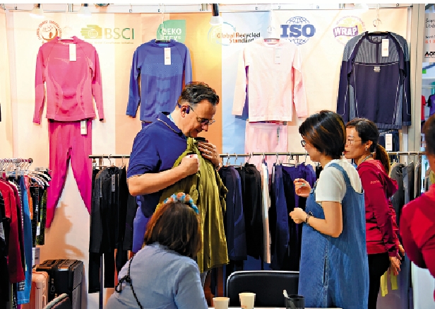 　　圖：外國客戶在廣交會挑選中國產服飾。\新華社