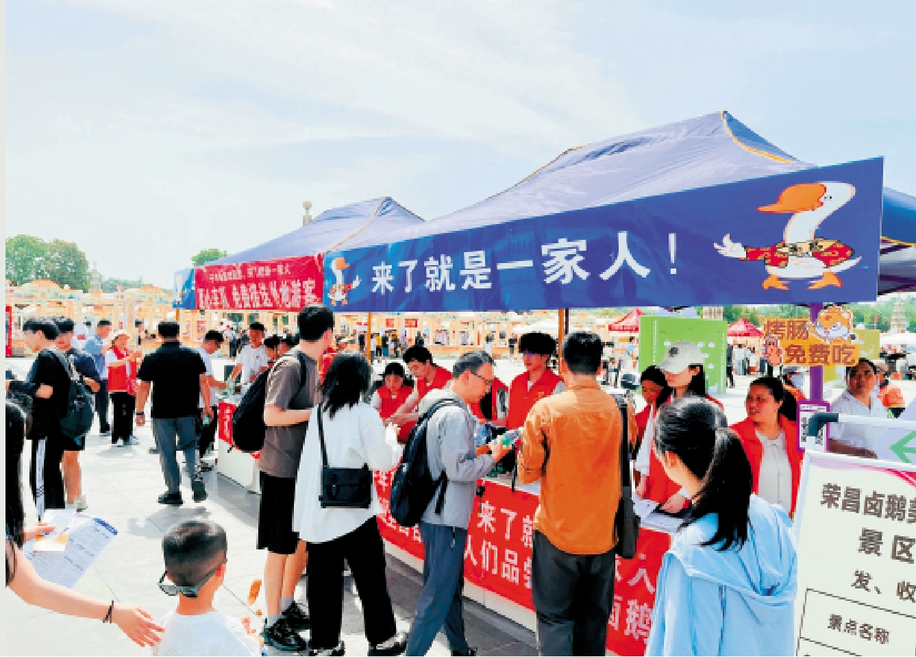 圖:榮昌旅遊爆火,在高鐵站外「來了就是一家人」標語下,志願者為遊客送礦泉水。\大公報記者韓毅攝