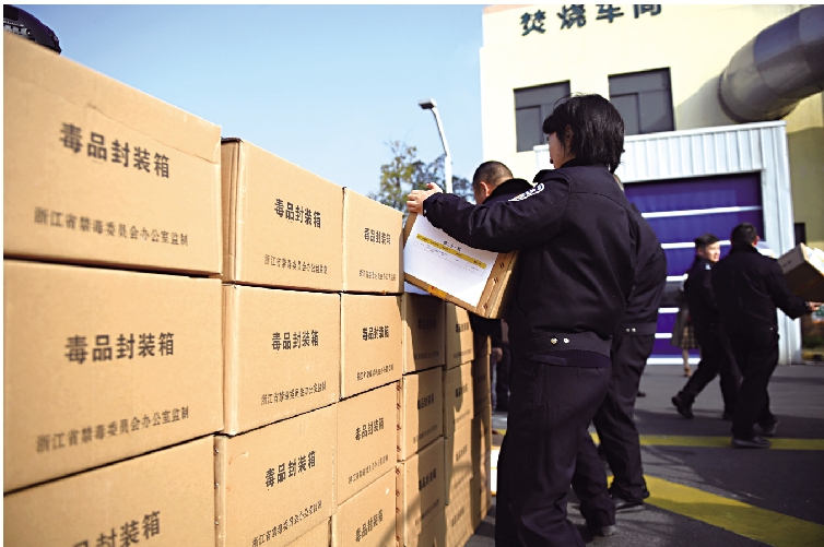 圖:公安人員將待銷毀的毒品搬運至銷毀點。\中新社