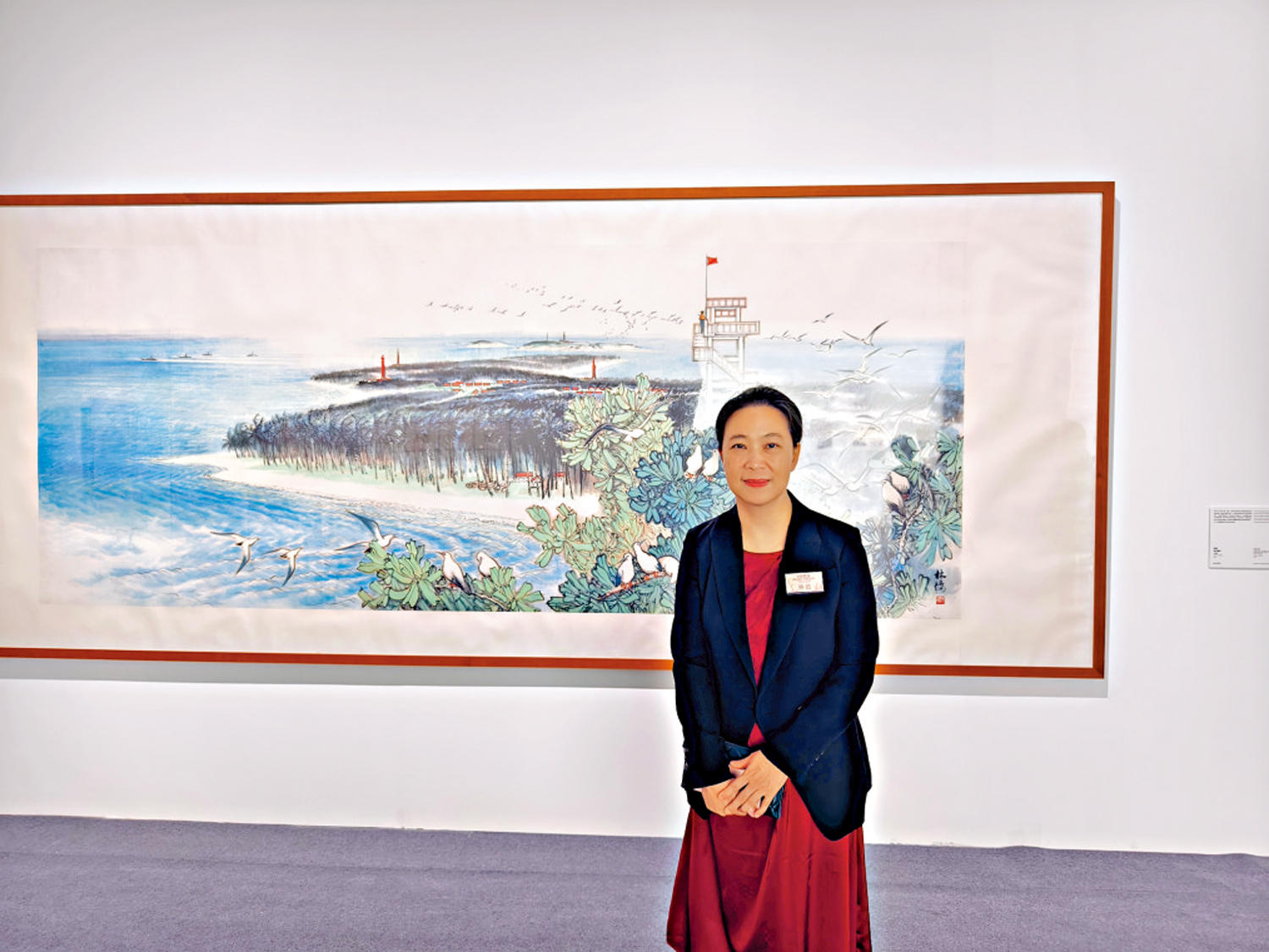　　圖：林藍與父親的作品一同在香港展出，對她而言意義非凡。圖為林藍站在其父親的畫作《西沙風光》前留影。\大公報記者李慧妍攝