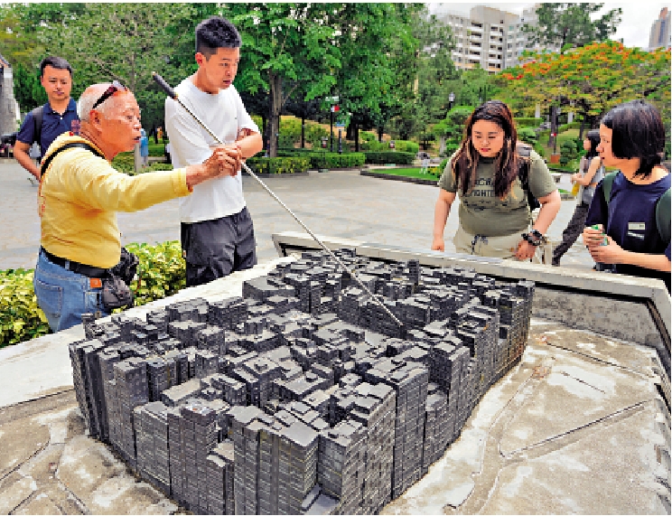 　　圖：杜小姐（右二）認為展覽設在九龍寨城公園內更具吸引力。左為從事免費導賞的敏叔。