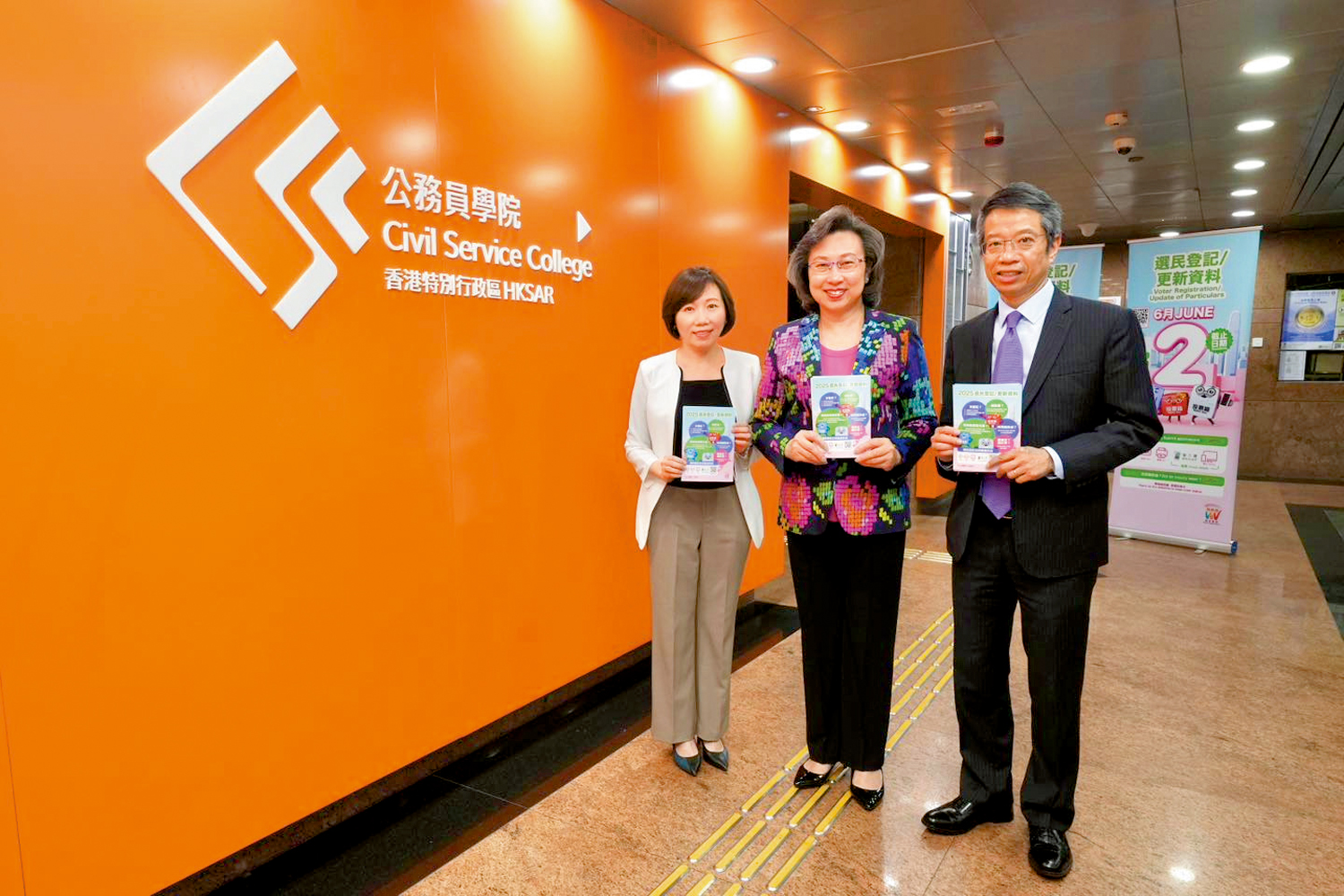 　　圖：楊何蓓茵前日在北角政府合署大堂派發選民登記單張，並到公務員學院的辦公室「洗樓」。