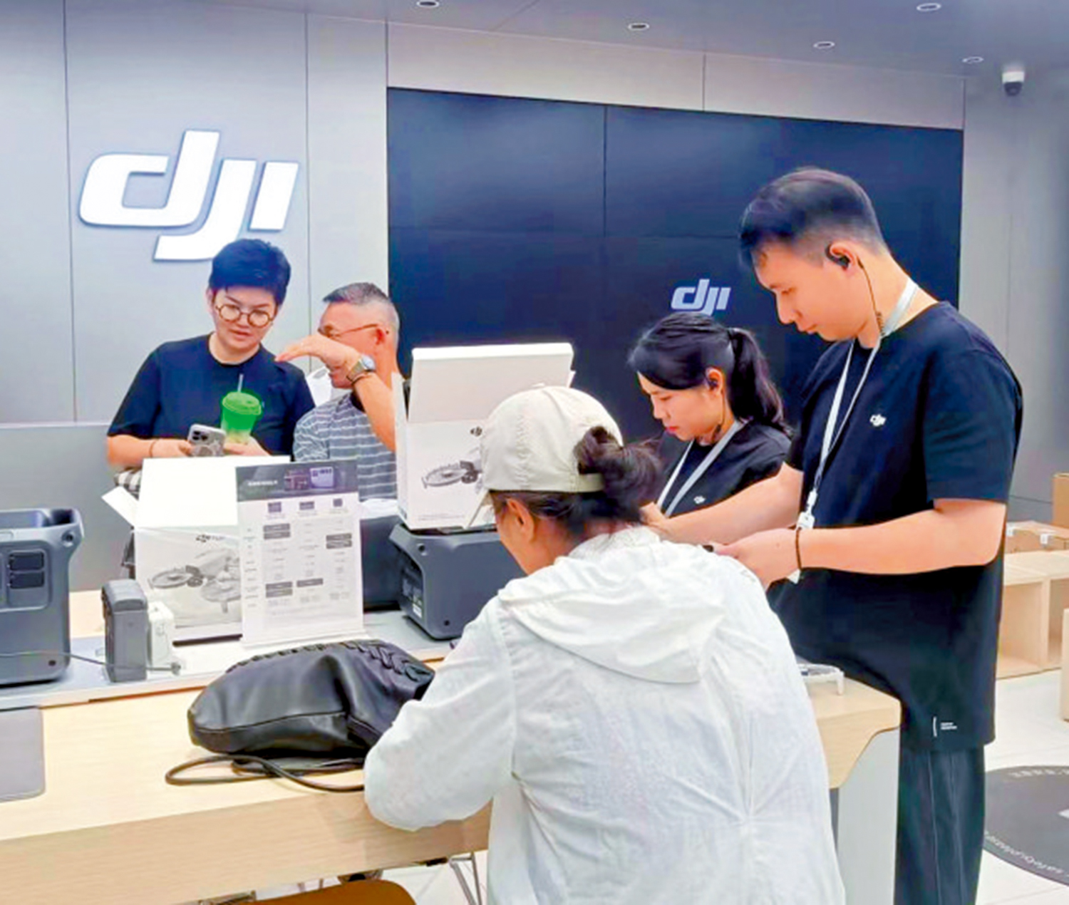 圖:無人機是遊客喜愛的商品。圖為一港人(後方男子)在購買大疆無人機。
