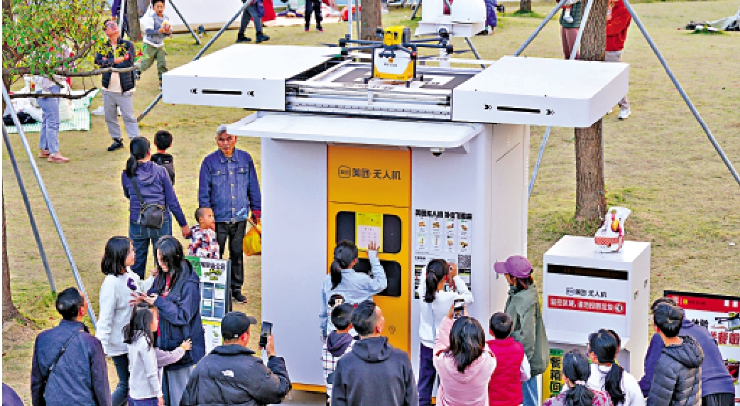 圖:人們在深圳筆架山公園體驗無人機送外賣。\新華社