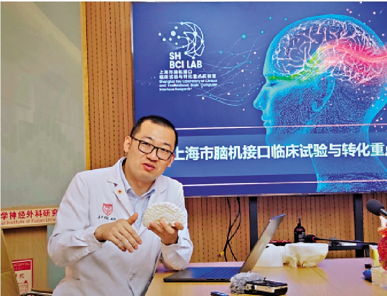 　　圖：復旦大學附屬華山醫院神經外科副主任醫師路俊峰向記者介紹腦機接口。\大公報記者劉凝哲攝