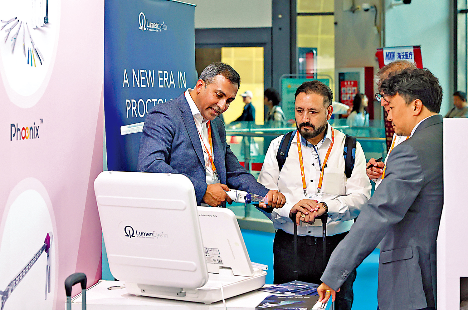 　　圖：在今年4月於上海舉辦的第91屆中國國際醫療器械博覽會上，展商（左）向參觀者介紹用於腔鏡手術的電動脗合器。\新華社