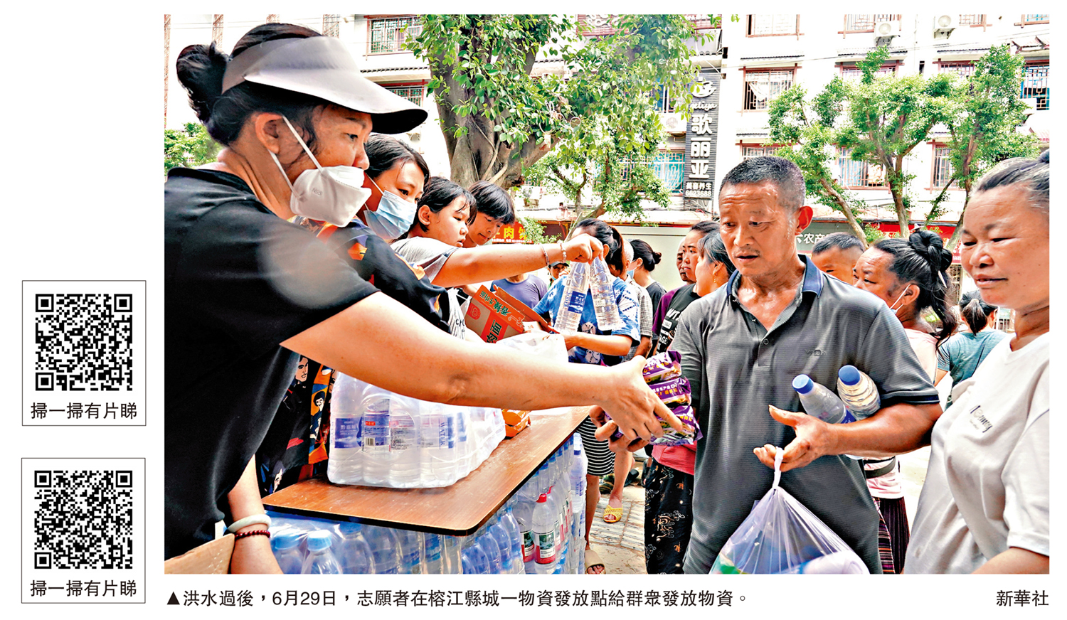 圖:洪水過後,6月29日,志願者在榕江縣城一物資發放點給群眾發放物資。\新華社
