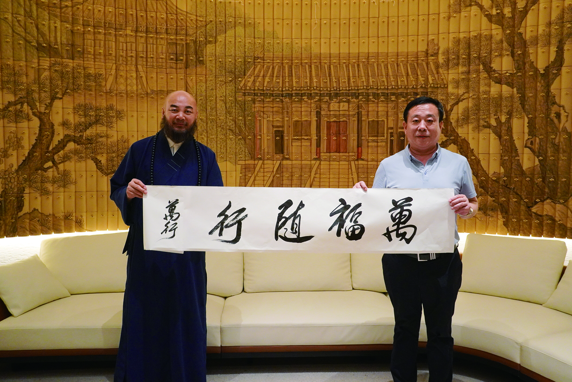 　　圖：萬行法師（左）向亞寶藥業集團黨委書記許振江（右）贈送墨寶