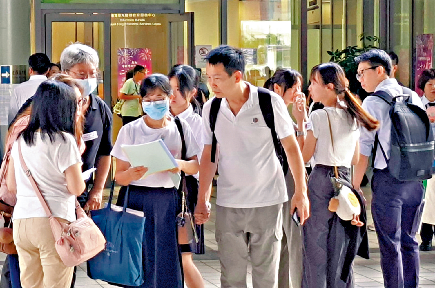 　　圖：升中派位昨日放榜，昨早有不少教師在九龍塘教育局學位分配組外「接學生」。