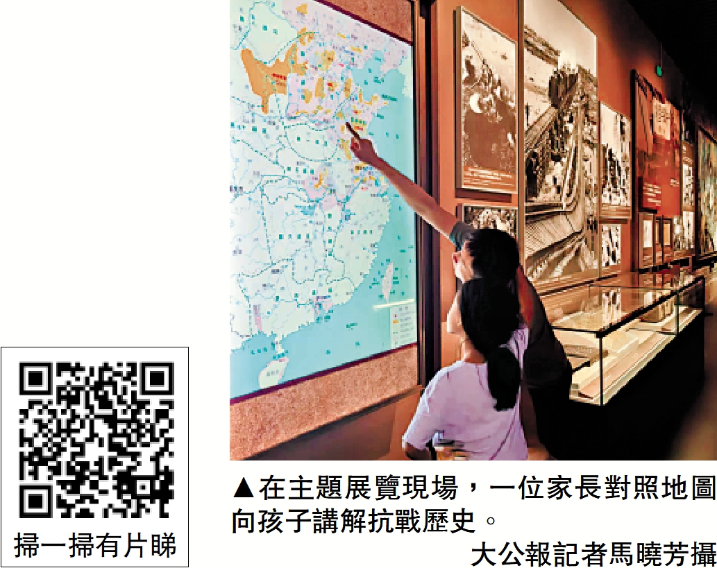 　　圖：在主題展覽現場，一位家長對照地圖向孩子講解抗戰歷史。\大公報記者馬曉芳攝