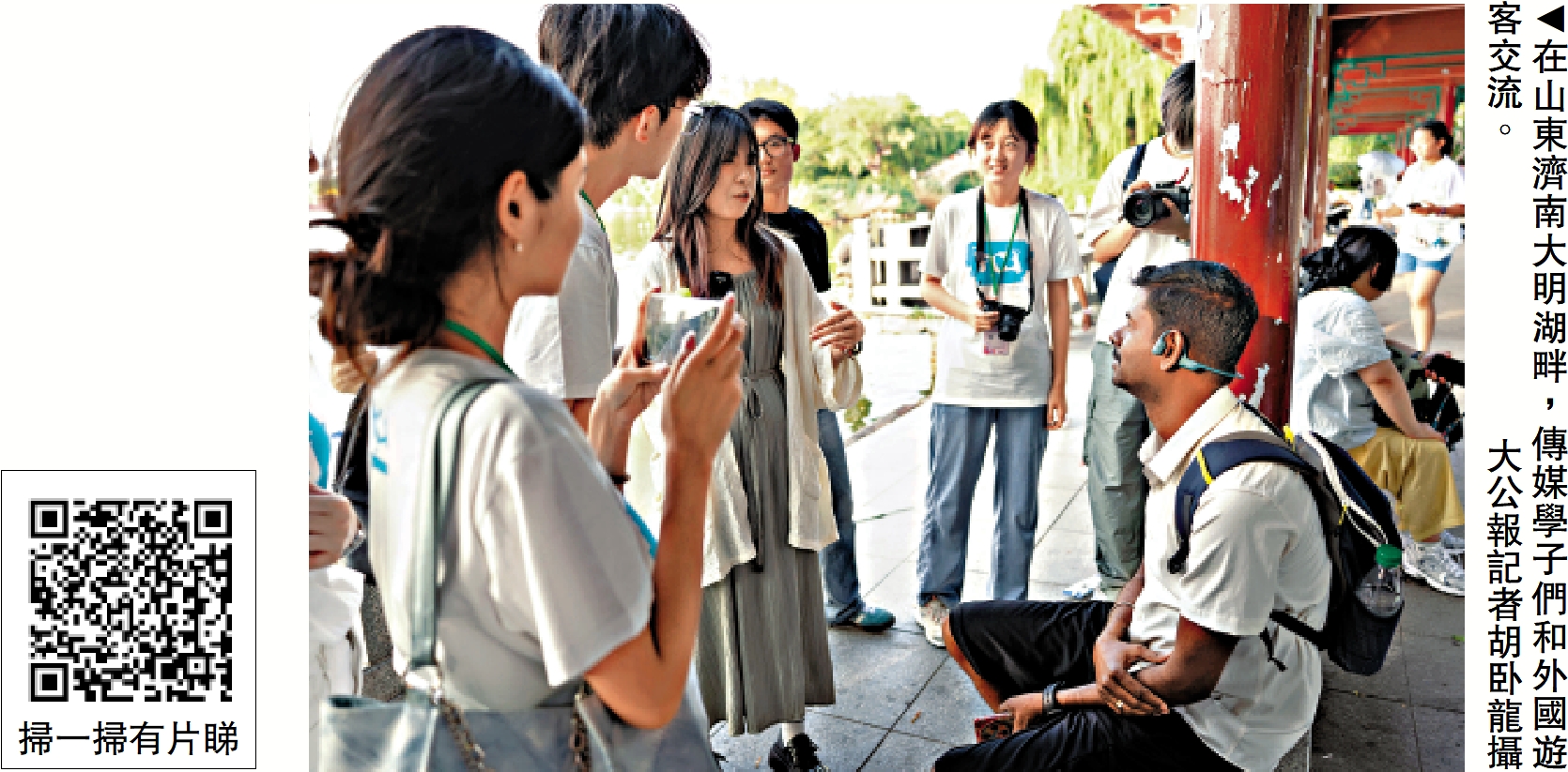 圖:在山東濟南大明湖畔,傳媒學子們和外國遊客交流。\大公報記者胡卧龍攝