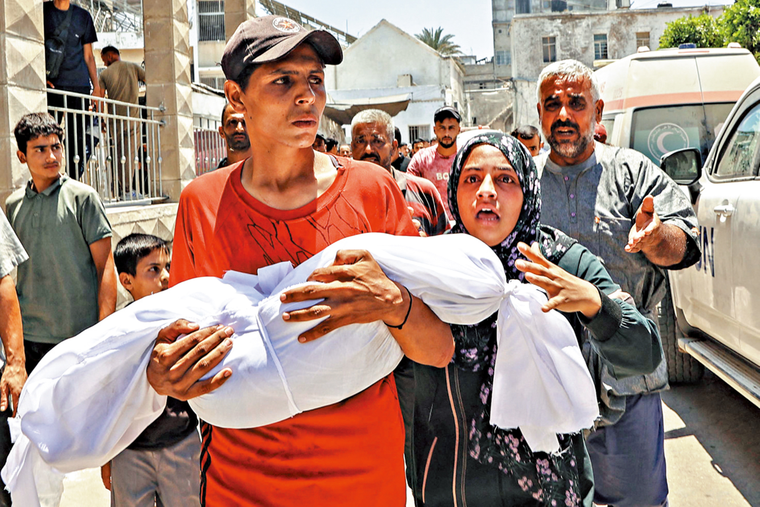 　　圖：一名巴勒斯坦男子13日搬運死於以軍空襲的兒童遺體。\法新社