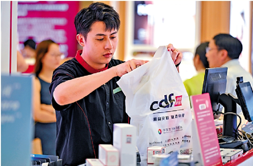 　　圖：海口日月廣場免稅店的工作人員為顧客打包免稅品。/新華社