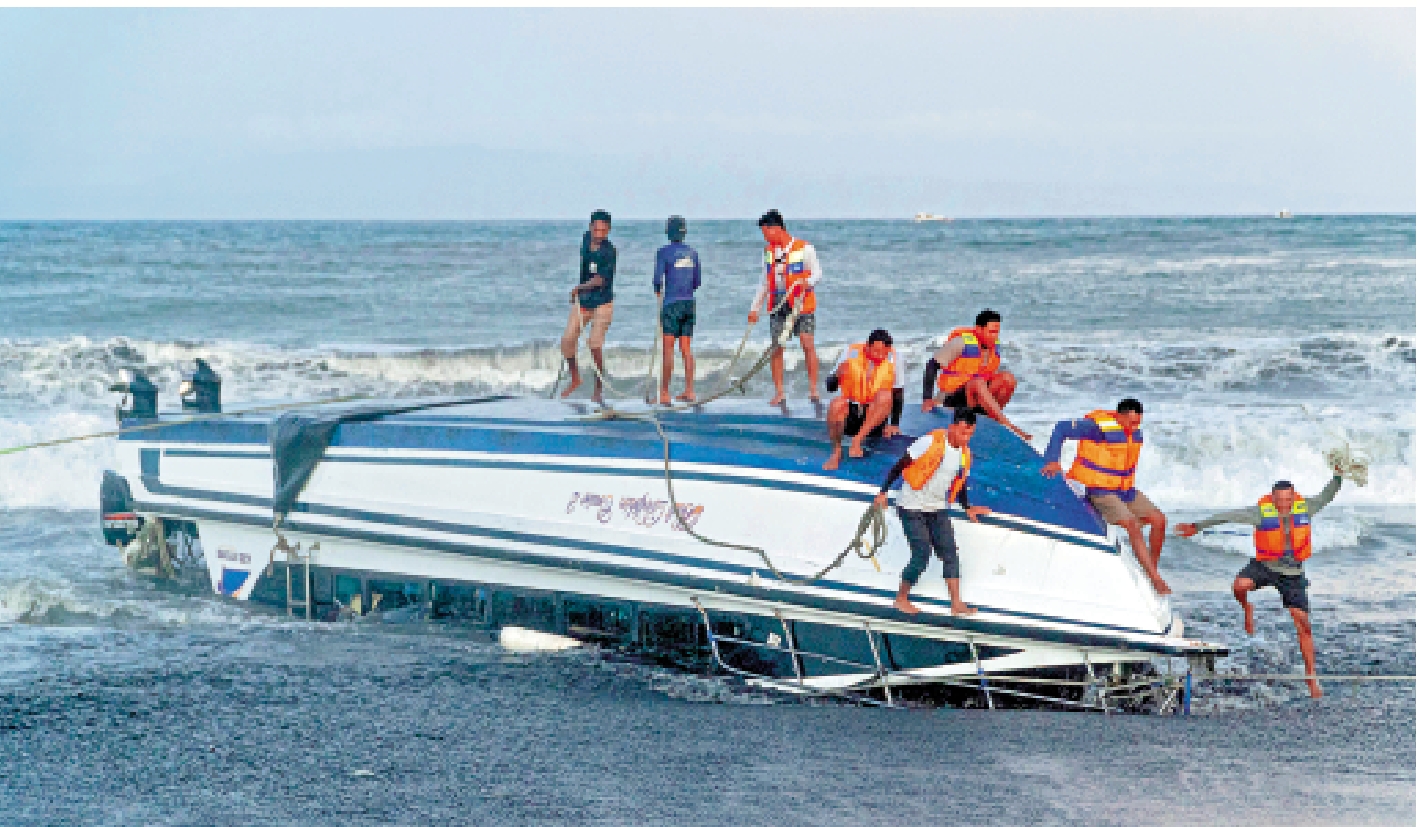 　　圖：8月5日，在印尼巴厘島，工作人員將傾覆快艇拉到岸邊。\新華社