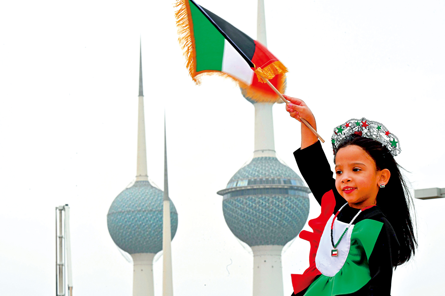 　　圖：海灣國家正全面推行能源轉型戰略，香港可發展碳交易所、伊斯蘭ESG基金等產品，構建「綠色＋清真」雙軌金融體系。圖為一名小女孩揮舞着科威特國旗旗幟。