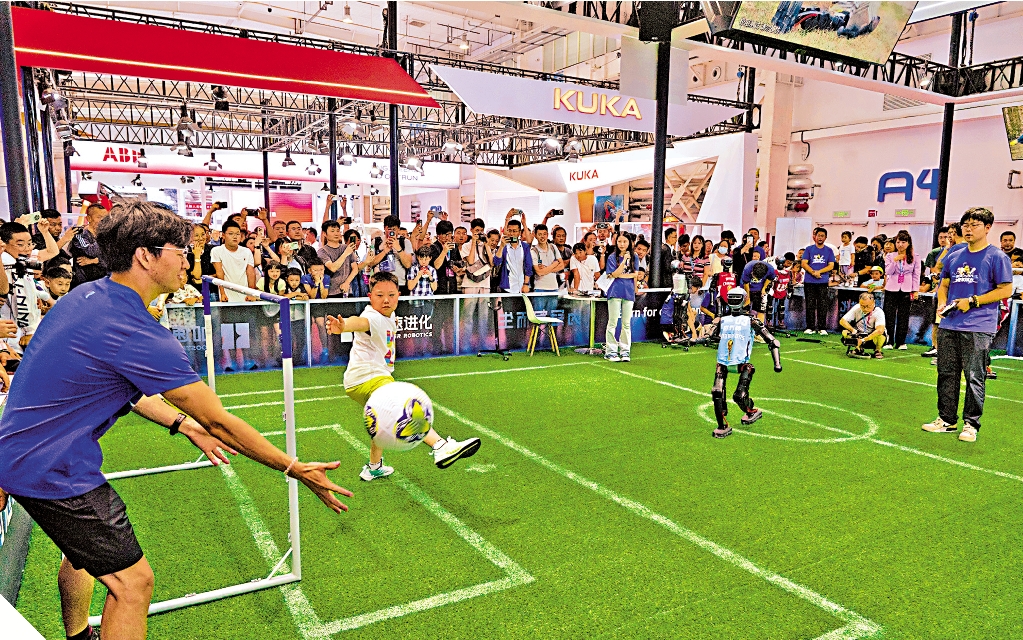 　　圖：踢足球/在加速進化展台，「人機大戰」互動踢球環節讓觀眾血脈沸騰。\新華社