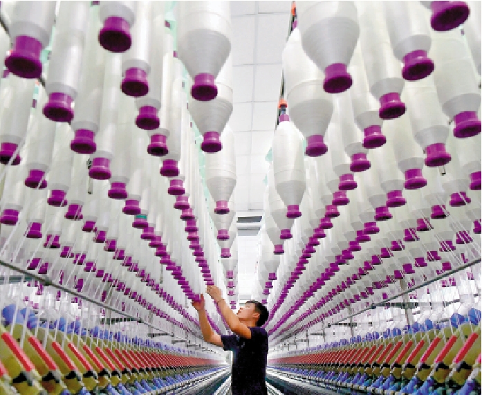 　　圖：在福州市一間紡織5G智慧工廠內，工人在生產線上作業。\中新社