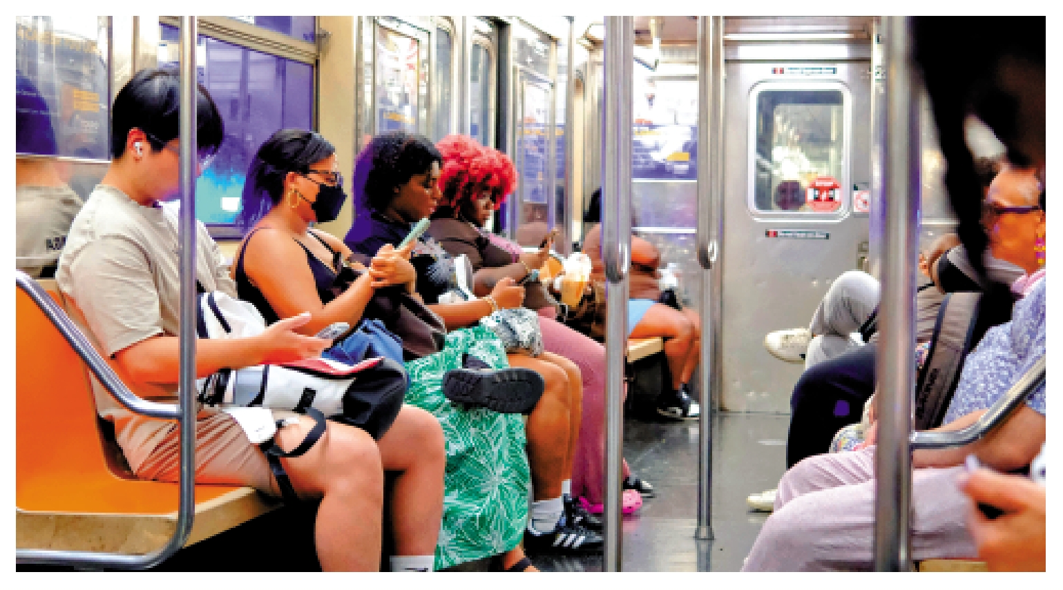 　　圖：在紐約曼哈頓區，人們在通勤時使用手機。\法新社