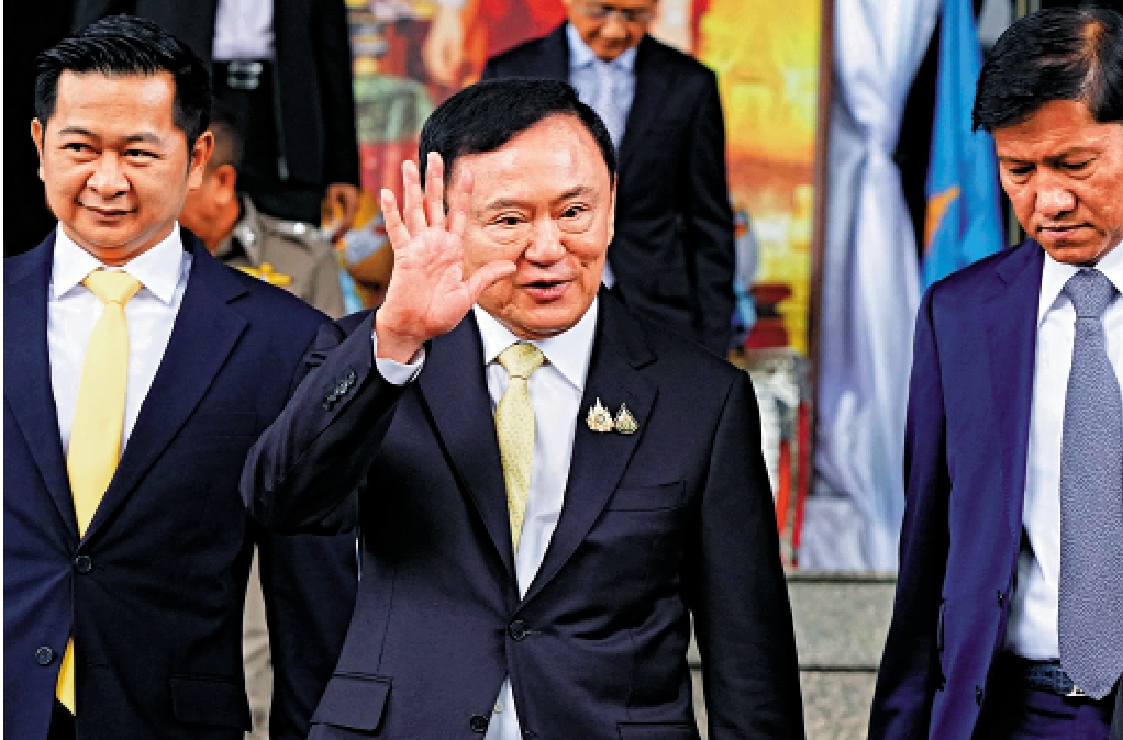 　　圖：泰國前總理他信（中）22日離開曼谷刑事法院。\法新社