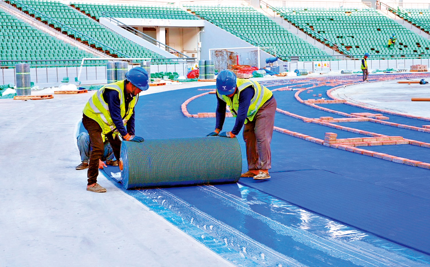 　　圖：廣州攜手「城市合夥人」共同辦好全運會賽事，跑道供應商為核心場館提供最高規格的賽事級預製型橡膠跑道。圖為工人在廣州大學城體育中心鋪設跑道。 受訪者供圖