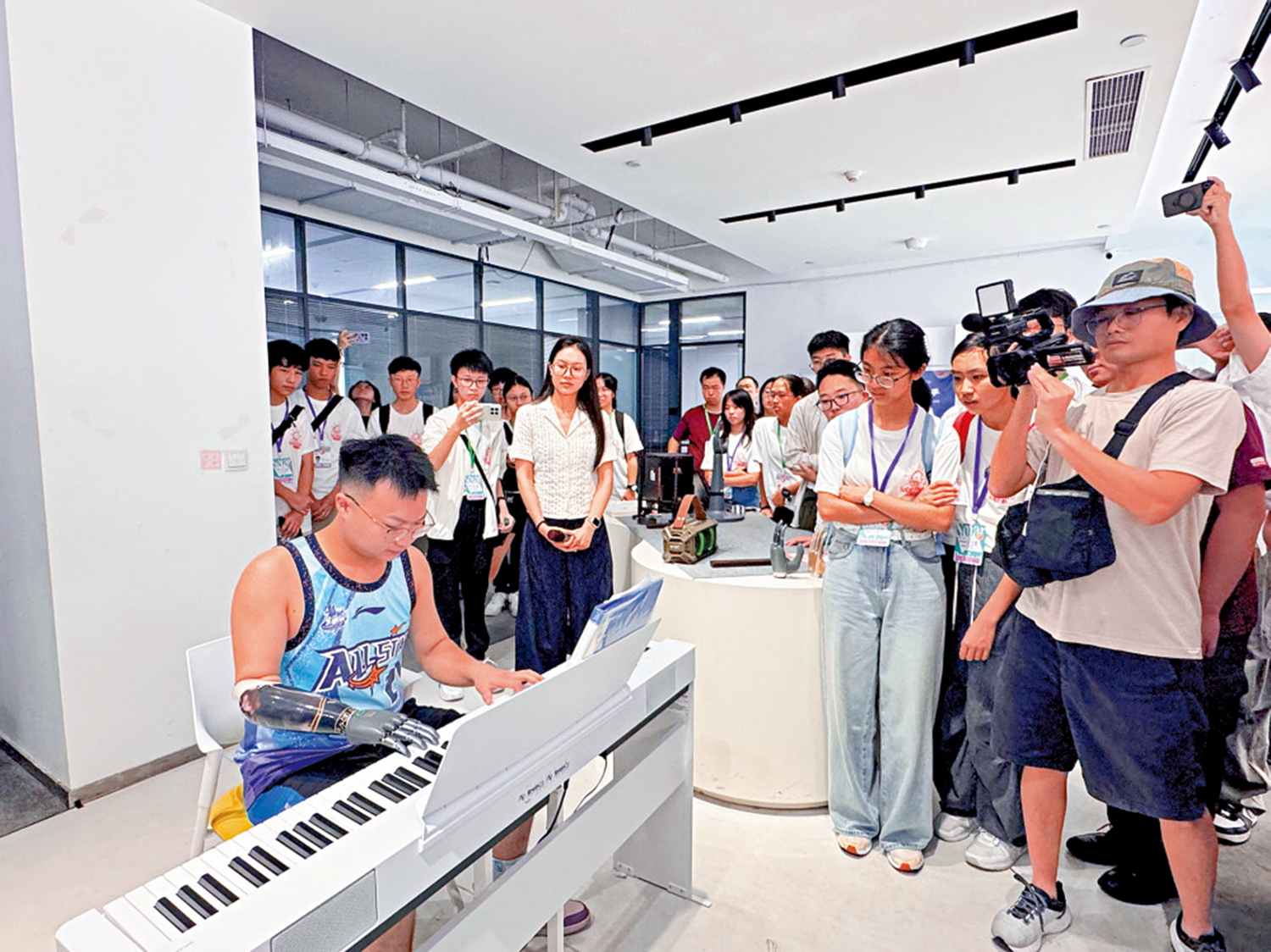 　　圖：交流團走進「杭州六小龍」企業之一的強腦科技，觀看殘障人士借助智能仿生手演奏電子琴。\大公報記者連慜鈺攝