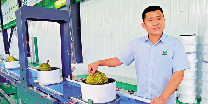 　　圖：鴻翔榴槤加工事業部總經理崔浩向大公報記者介紹智能化榴槤AI檢測分選線。/大公報記者何玫攝