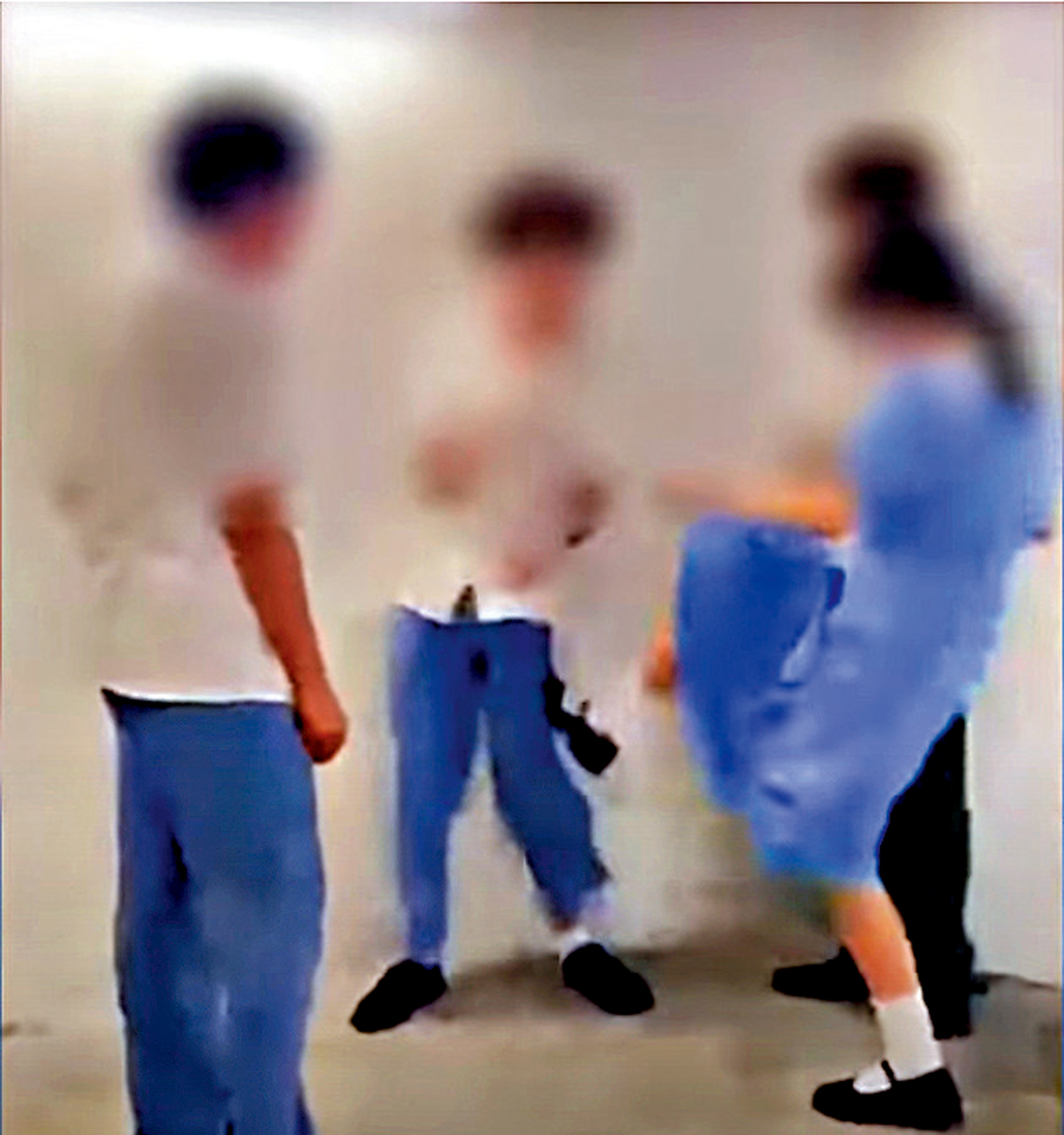 　　圖：一名男學生被兩男一女學生包圍，並多次被掌摑，其中一名女學生更起腳踢受害人。\網上視頻截圖