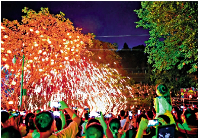 　　圖：遊客在深圳甘坑古鎮欣賞非遺打鐵花。\受訪者供圖