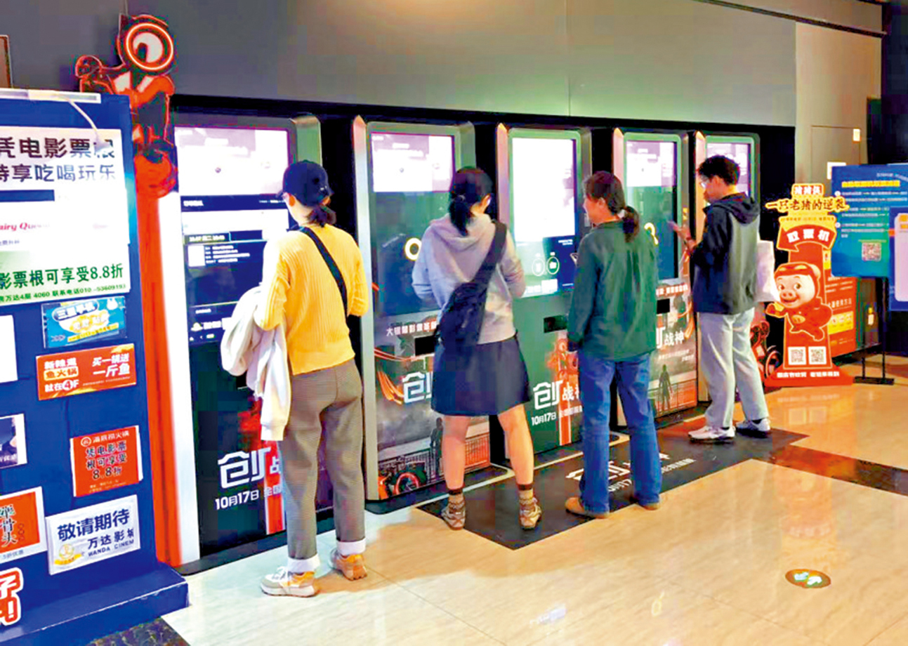 　　圖：在北京一家影城，觀眾在自助取票機前取票入場。\大公報記者任芳頡攝