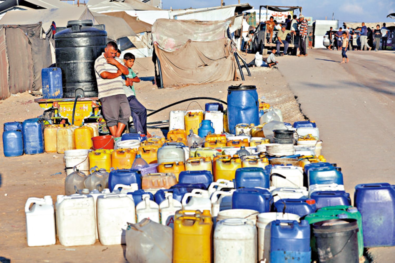 　　圖：加沙南部汗尤尼斯的巴勒斯坦人等待水資源援助。\路透社