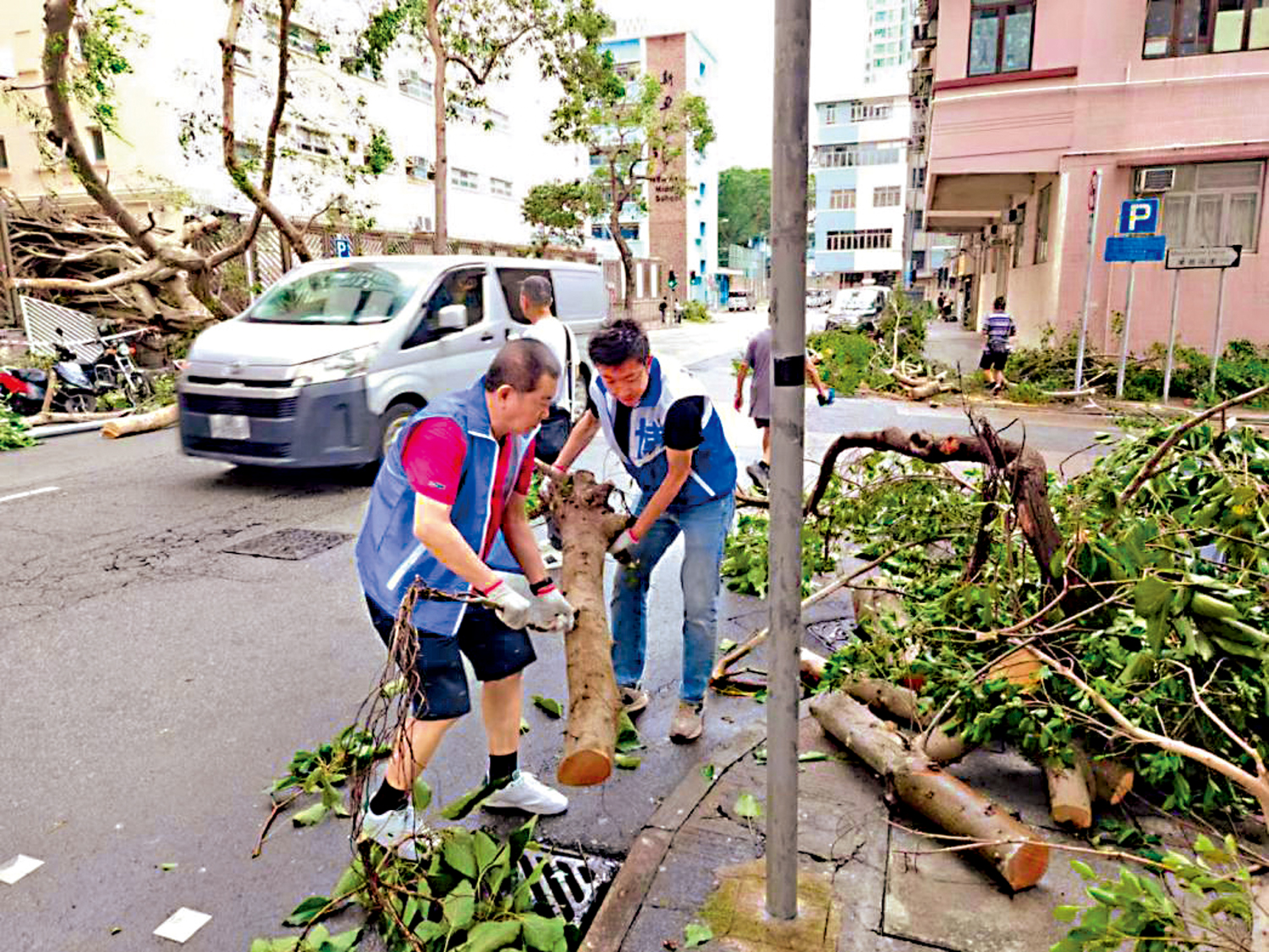 　　圖：林博與關愛隊清理颱風後倒塌的樹木。