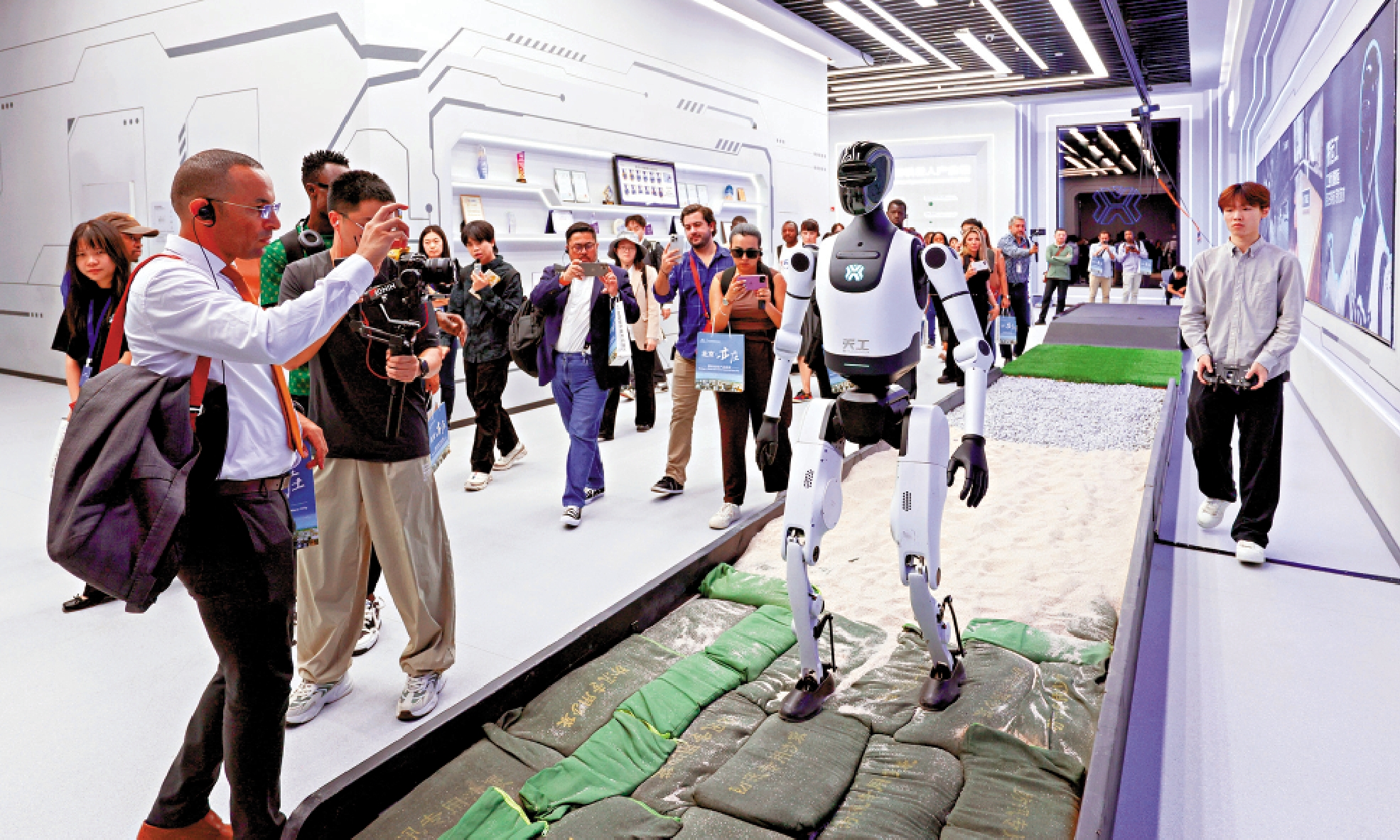 　　圖：「人工智能＋」已深入製造、金融、醫療等重點行業領域，形成經濟增長新引擎。圖為外國記者參觀中國智造的「天工」人形機器人在不同地形的行走能力。\中新社