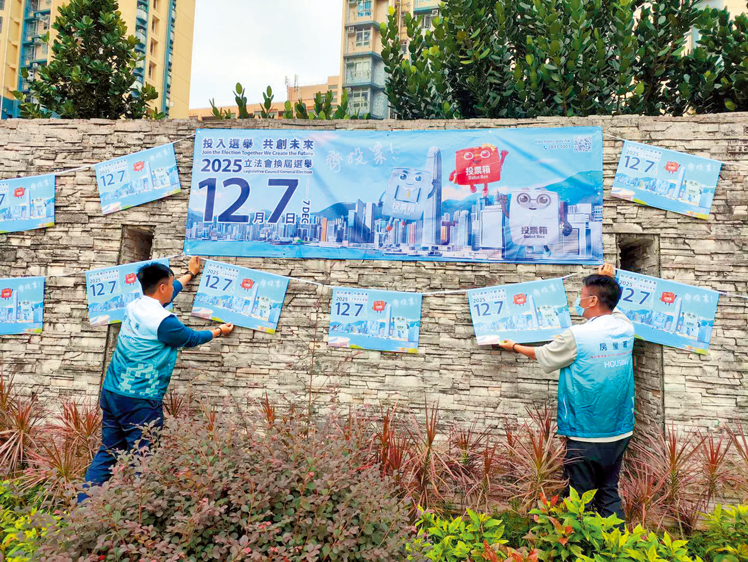 　　圖：房屋署人員加緊在屋邨範圍貼上立法會選舉宣傳海報。