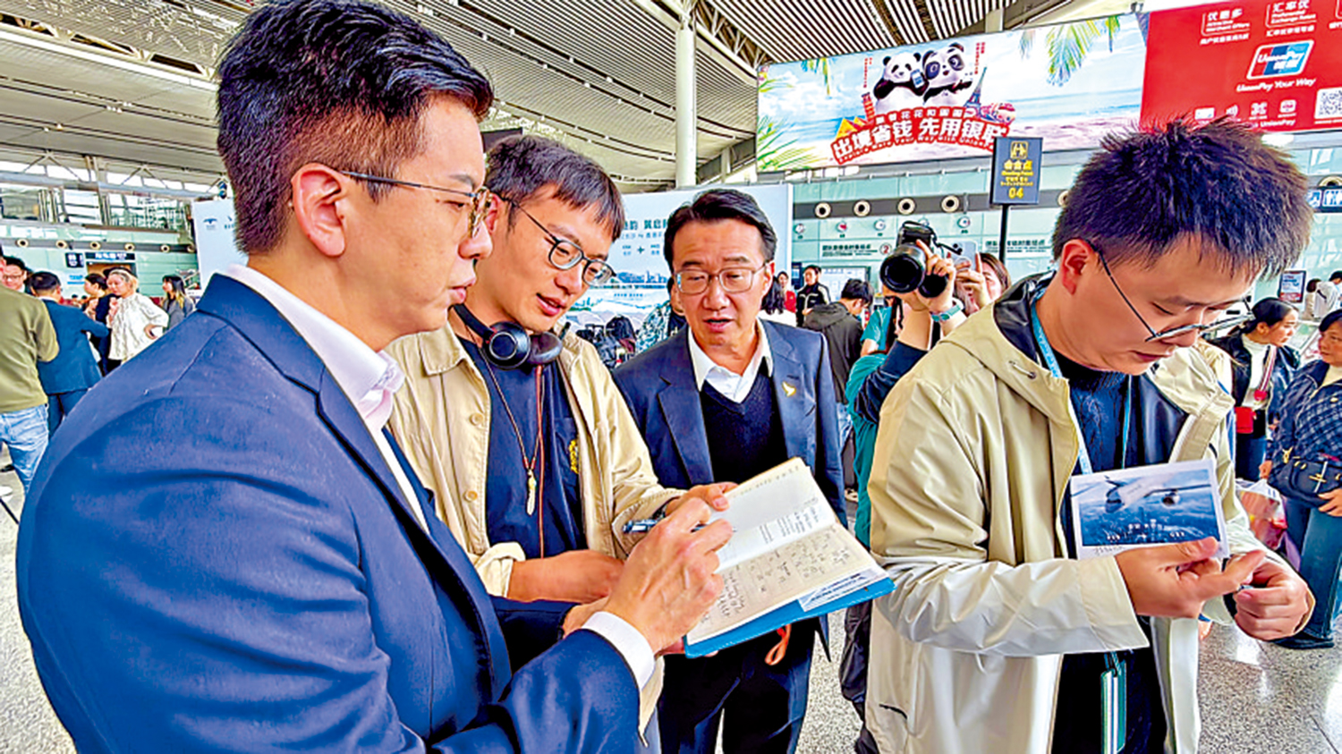 　　圖：林紹波（左一）為航空迷簽名。\大公報記者林靜文攝
