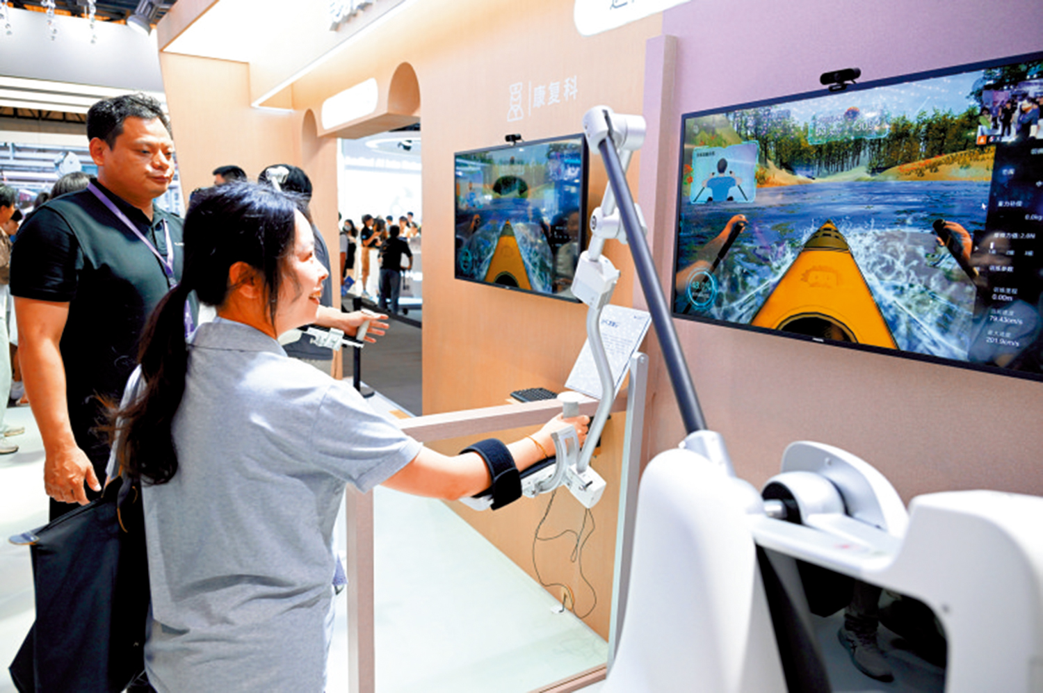 　　圖：7月26日，參觀者在2025世界人工智能大會上體驗三維上肢康復機器人。\中新社