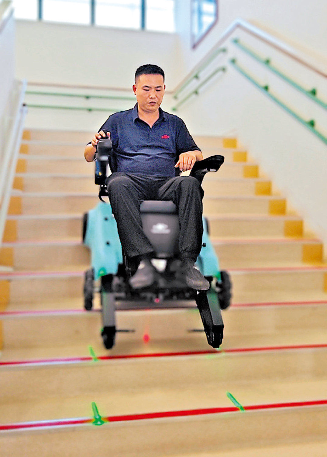 　　圖：工作人員演示能夠獨立正向反向上下樓梯、自由穿越複雜地形的全地形輪椅。\大公報記者黃寶儀攝