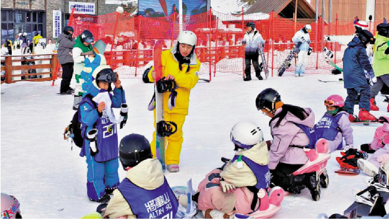 　　圖：新疆阿勒泰市將軍山國際滑雪度假區的滑雪教練正在向孩子們講解如何穿戴雪板。\新華社