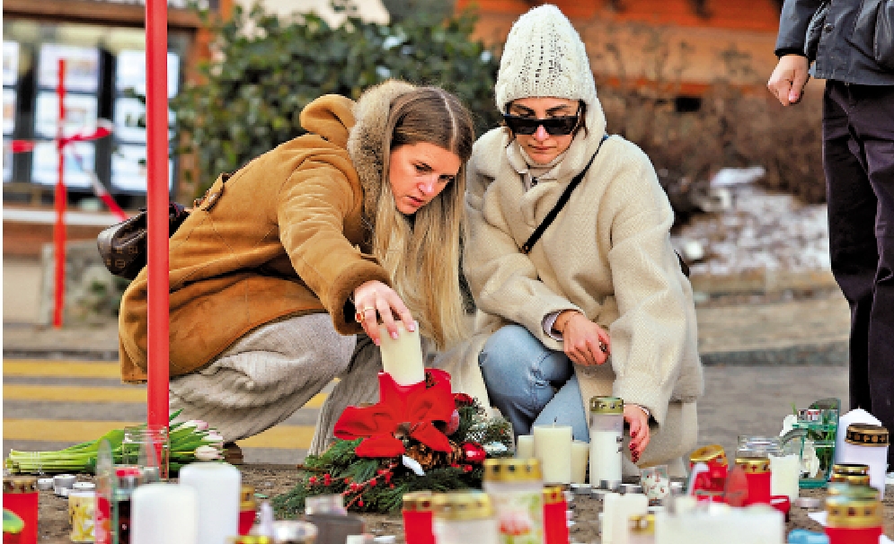 　　圖：1月2日，兩名女子在酒吧外擺放蠟燭悼念遇難者。\路透社