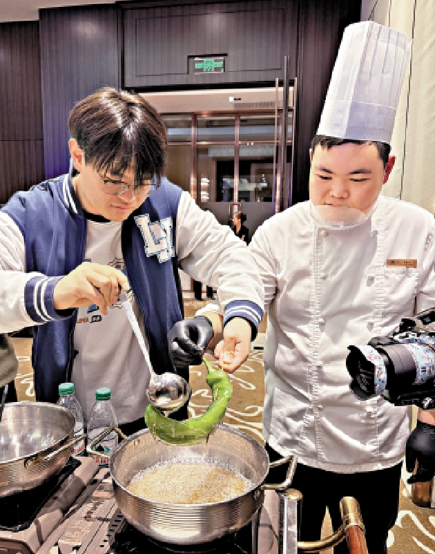 　　圖：酒店廚師趙春達（右）詳細介紹了冰糖葫蘆的製作過程。\大公報攝