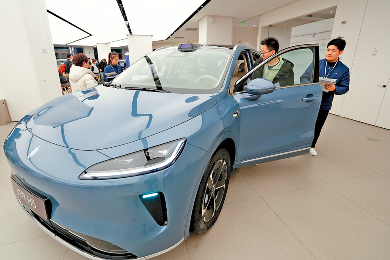 　　圖：1月1日，消費者在北京一家門店了解新能源汽車。\中新社