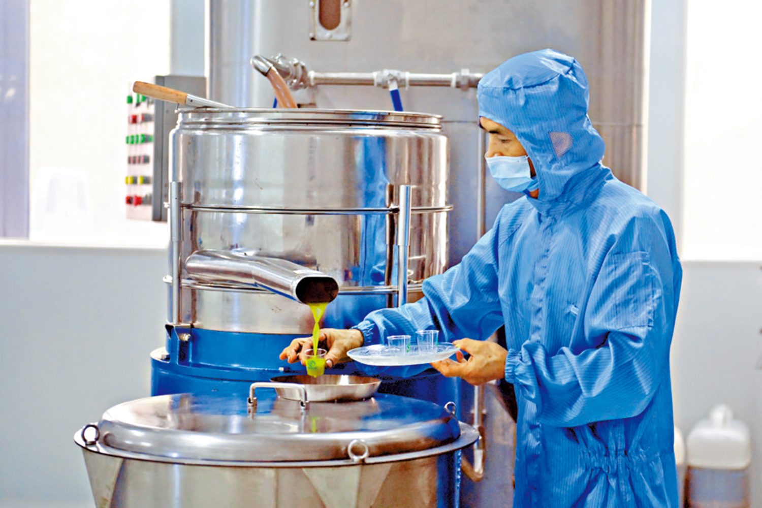 　　圖：在橄欖油加工車間內，工作人員抽取樣本檢驗。