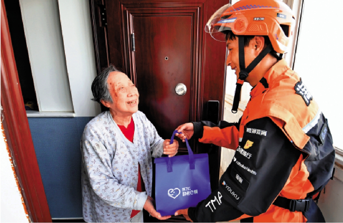 　　圖：北京朝陽區香河園街道藍騎士驛站的配送員為老人送餐上門。\新華社