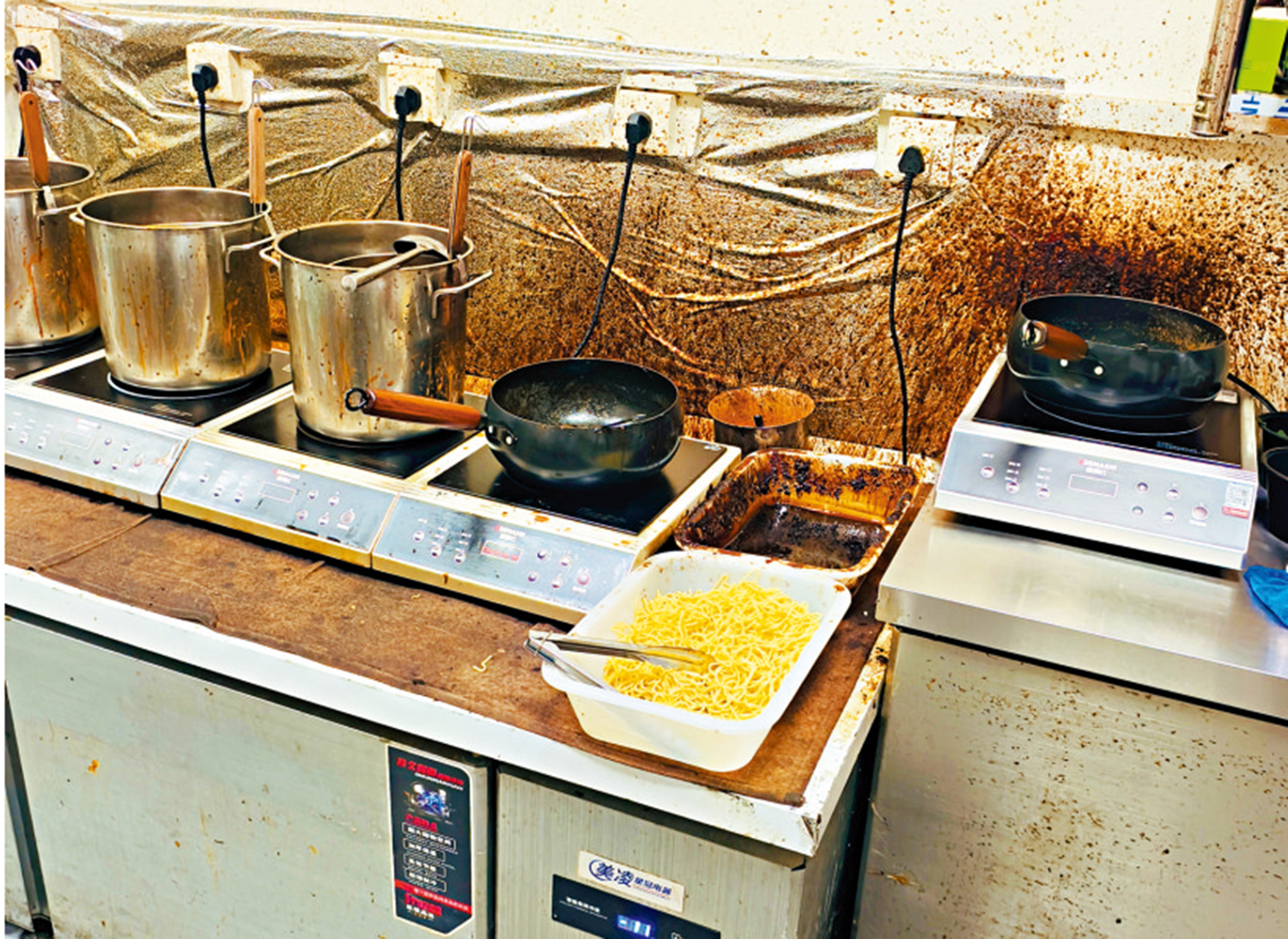 　　圖：曹氏鴨脖的廚房灶台緊貼門口，油污厚重，牆面瓷磚早已變成黑褐色。\大公報記者韓毅攝