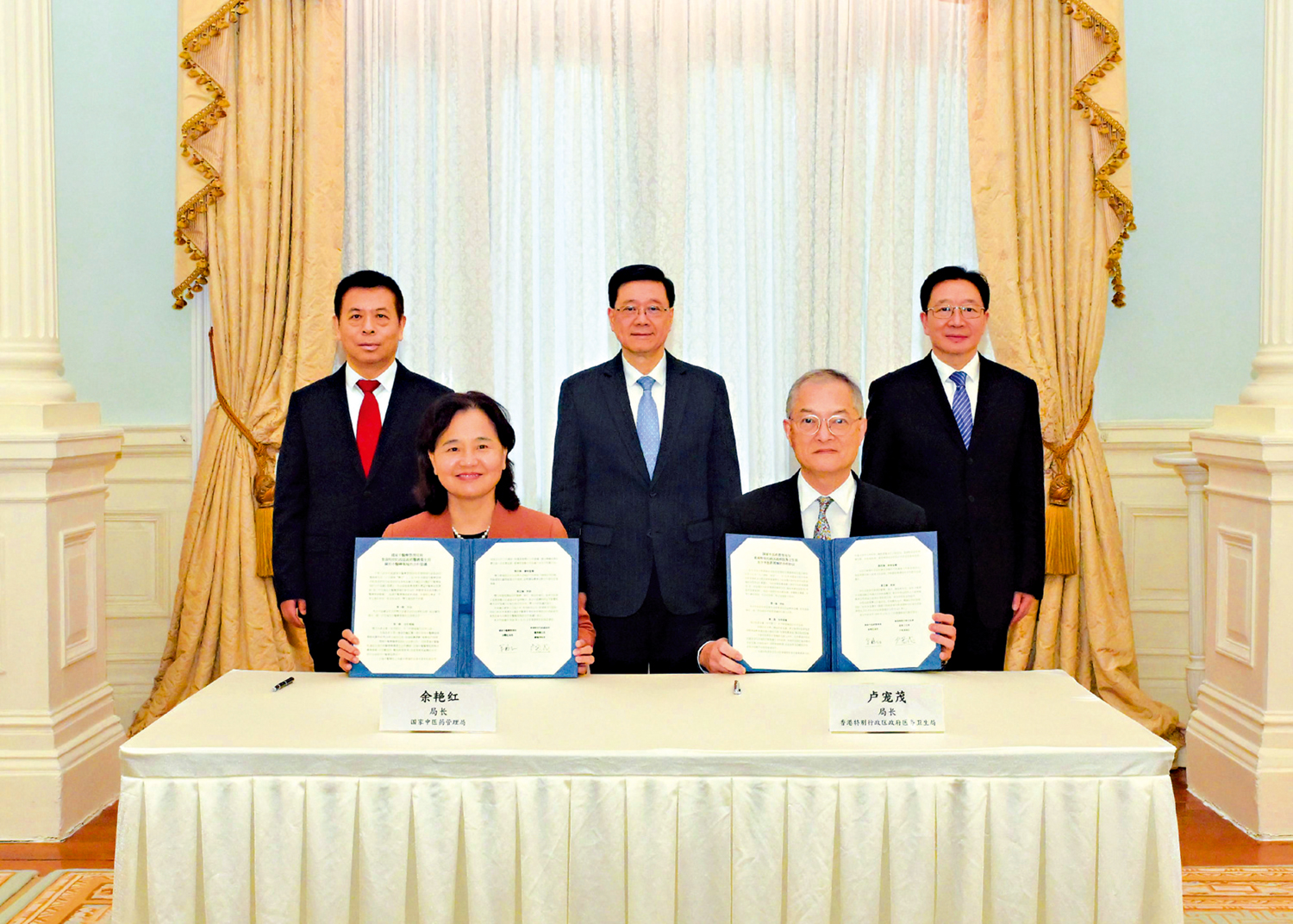 　　圖：行政長官李家超、國家衞健委主任雷海潮和中央政府駐港聯絡辦主任周霽，見證國家中醫藥管理局局長余艷紅和醫衞局局長盧寵茂簽署《中醫藥合作協議》。