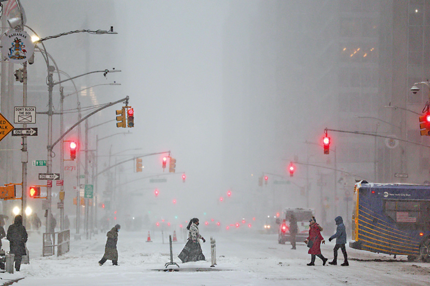 　　圖：紐約曼哈頓區飄雪，行人在雪中穿梭於第六大道。\法新社