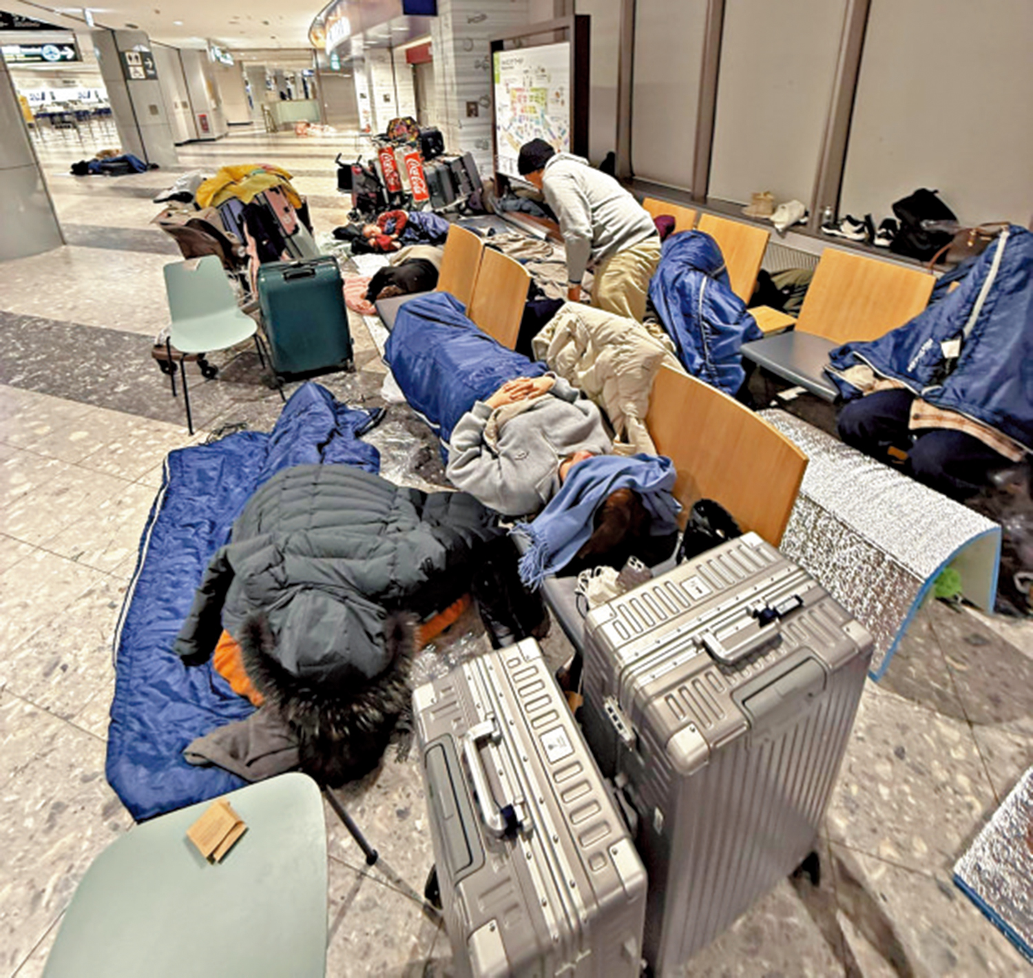 　　圖：滯留機場的旅客打地鋪或躺在座椅上。\網絡圖片