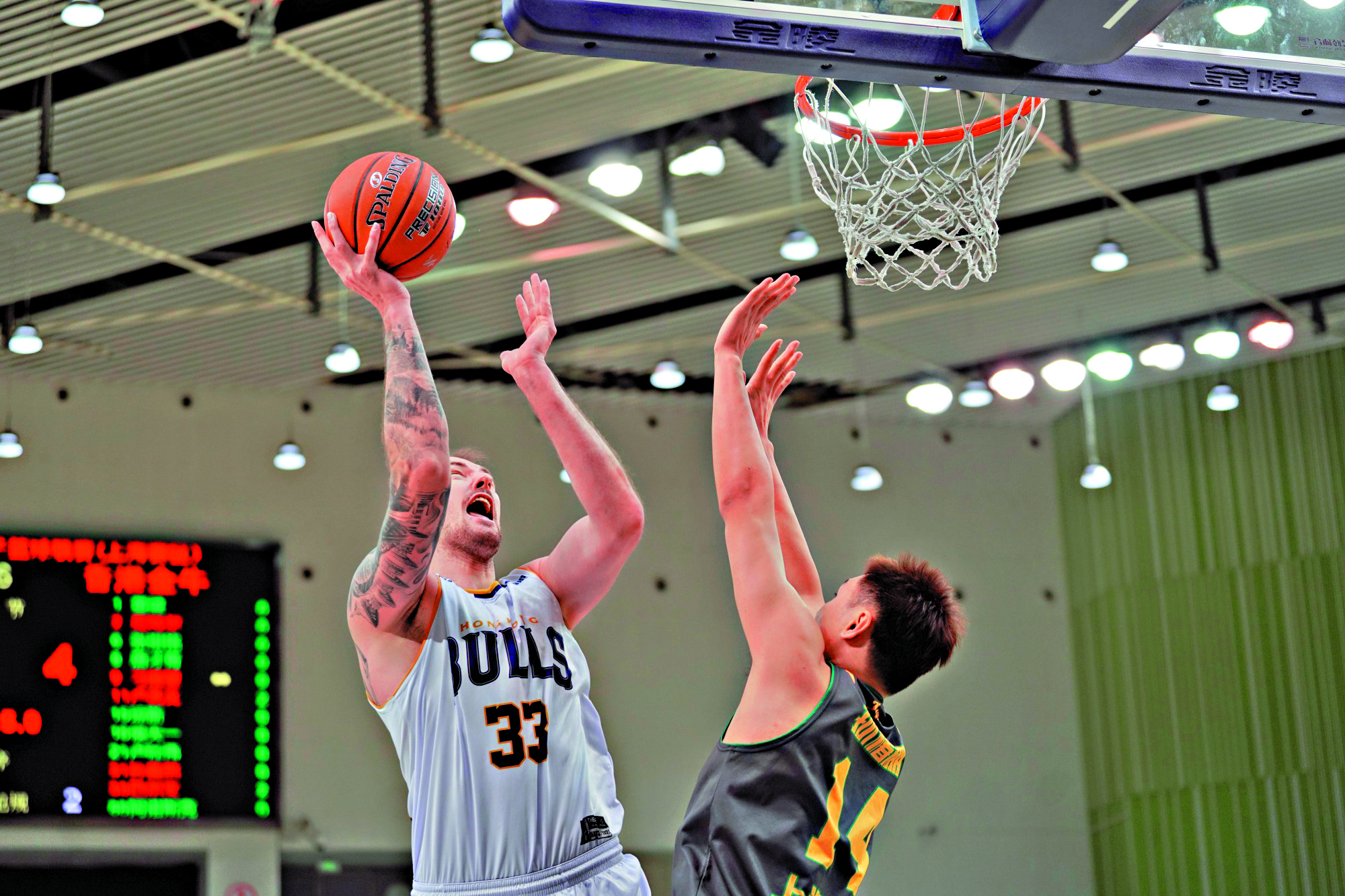 　　圖：金牛男籃球員巴爾文（左）奮力上籃。