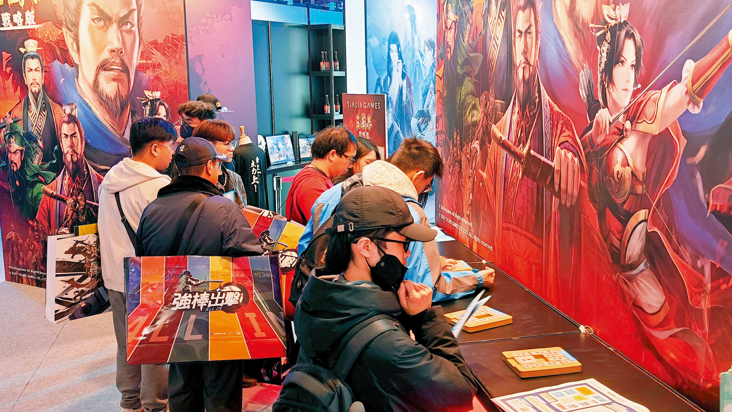 　　圖：在台北國際電玩展，玩家們在《三國志·戰略版》遊戲展台前體驗滑塊遊戲「華容道」。\新華社